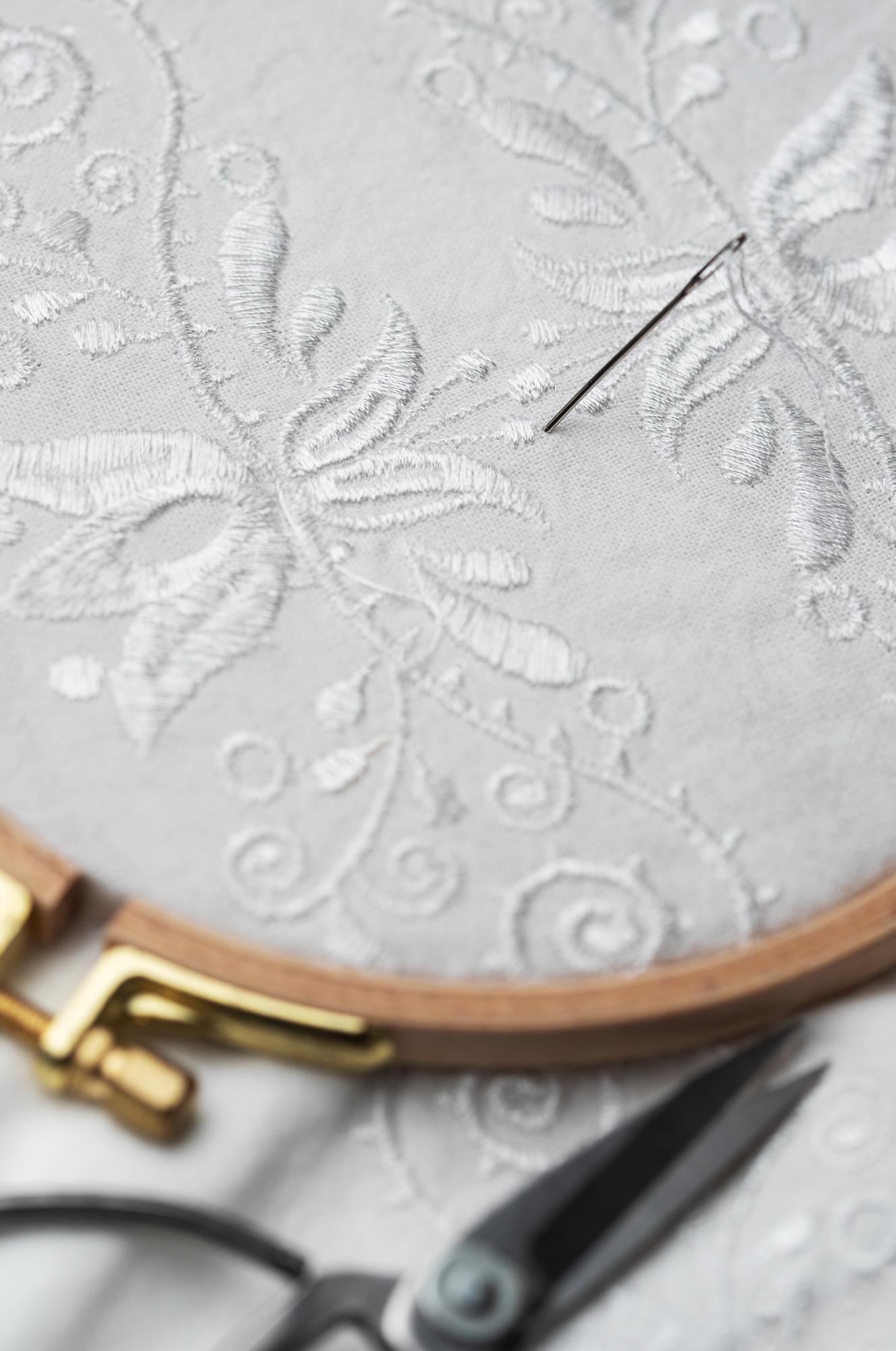 Close-up luxury hand embroidery on linen with gold thread